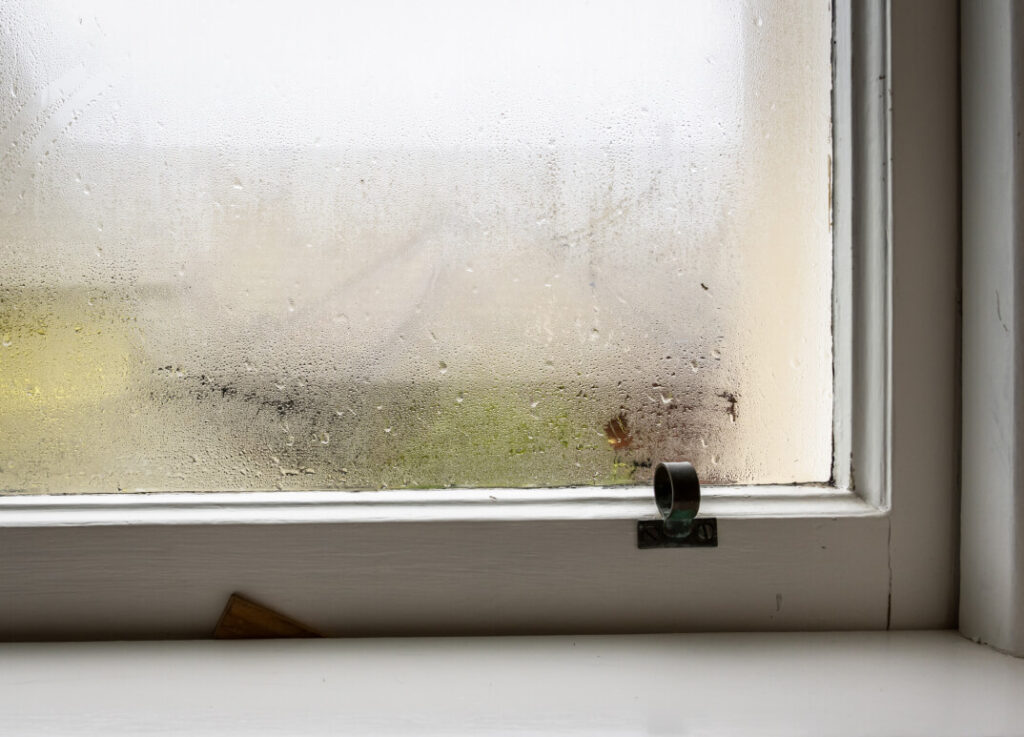 An image of a window with a wet window sill, showcasing the challenges of single glazed windows.