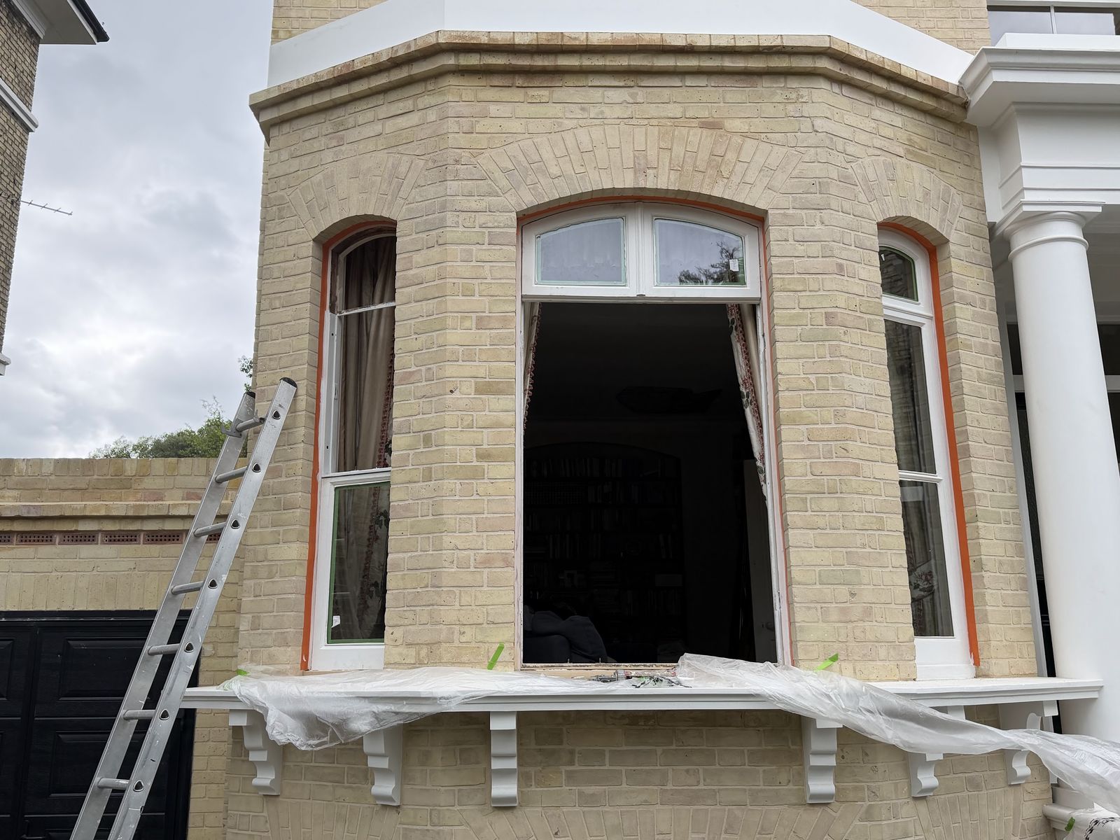 Victorian bay with a sash window removed for restoration and draught proofing, sill masked ready for work